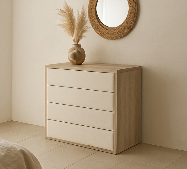 Habitación con una cómoda en madera roble con cajones tapizados y un espejo.
